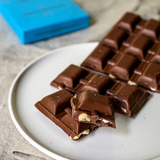 Pezzi della tavoletta al latte con nocciole serviti nel piatto