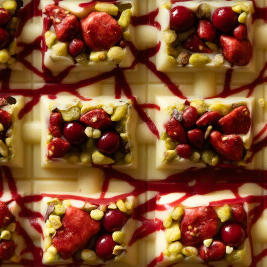 Tavoletta di cioccolato bianco con fragole e pistacchi in superficie