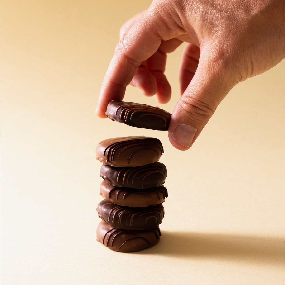 Mano che impila i baci al cioccolato