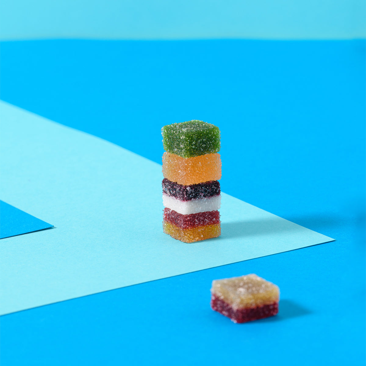 Pila di caramelle gelée alla frutta a strati su sfondo azzurro