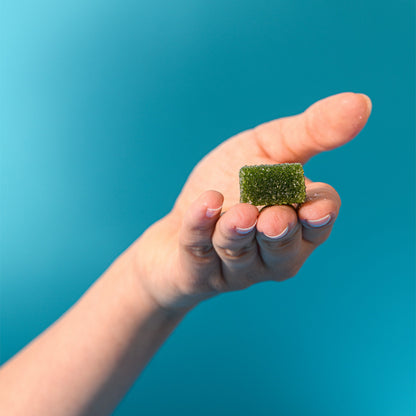 Caramella gelée alla mela verde tenuta in mano