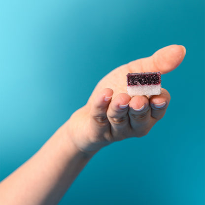 Caramella gelée a due strati cocco e ciliegia tenuta in mano
