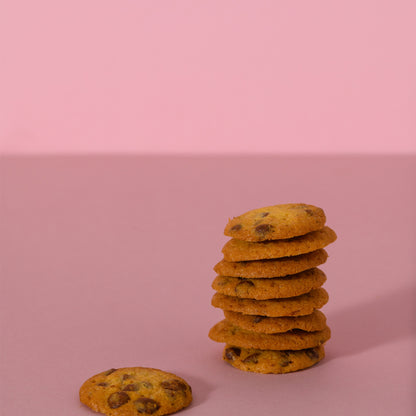 Cookies al cioccolato impilati su sfondo rosa