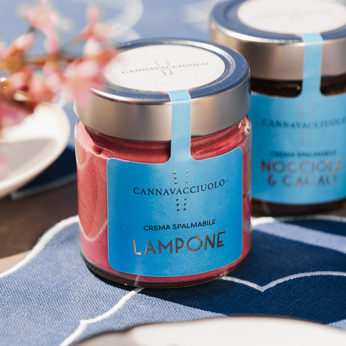 Vasetto di crema spalmabile al lampone in tavola con fiori
