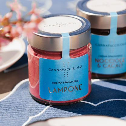 Vasetto di crema spalmabile al lampone in tavola con fiori