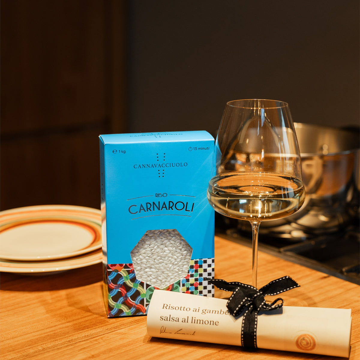 Confezione di riso Carnaroli in tavola con calice di vino