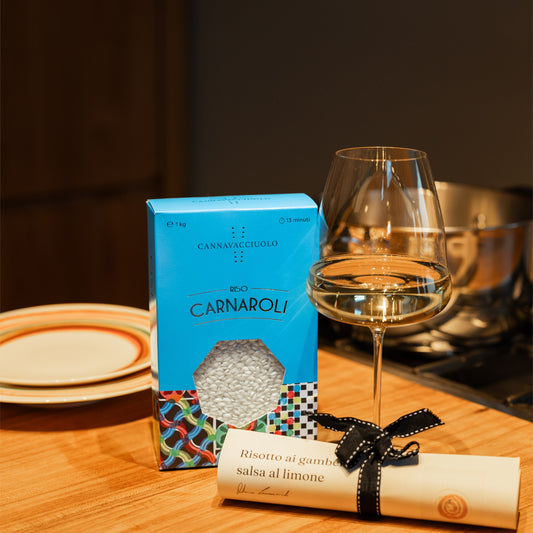 Confezione di riso Carnaroli in tavola con calice di vino