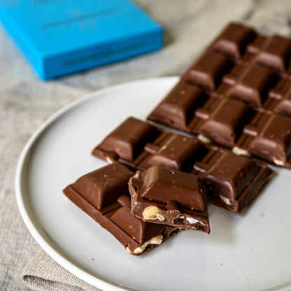 Pezzi della tavoletta al latte con nocciole serviti nel piatto