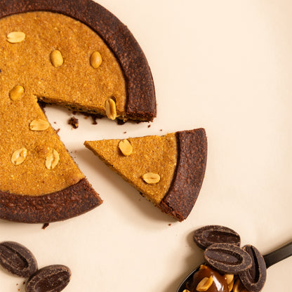 Fetta di torta arachidi, caramello salato e cioccolato